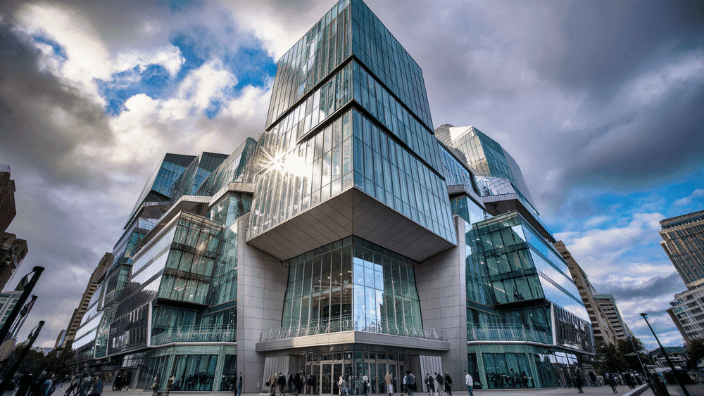 Nessa imagem tempos um edifício comercial grande em um centro urbano com uma rua movimentada